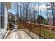 Expansive wooden deck with railing offers outdoor living space and overlooks a lush, wooded backyard at 4228 Bibleway Ct, Holly Springs, NC 27540