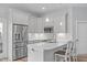 Modern kitchen features stainless steel appliances, a center island with seating, and ample counter space at 4228 Bibleway Ct, Holly Springs, NC 27540
