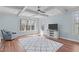 Bright living room featuring a coffered ceiling, hard wood floors, large windows, and comfortable seating at 4228 Bibleway Ct, Holly Springs, NC 27540