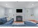 Cozy living room featuring a fireplace, built-in cabinets, and comfortable blue sectional at 4228 Bibleway Ct, Holly Springs, NC 27540