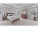 Spacious main bedroom with natural light, trey ceiling, carpet, and complemented by wooden furnishings and a ceiling fan at 4228 Bibleway Ct, Holly Springs, NC 27540