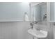 Charming powder room featuring wainscoting detail, a pedestal sink, and stylish decor at 4228 Bibleway Ct, Holly Springs, NC 27540