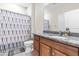 Bathroom featuring a granite countertop, wooden cabinetry, and a shower with stylish patterned curtain at 424 Hopwood Way Way, Apex, NC 27523