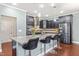 Modern kitchen features an island with granite counters, stainless steel appliances, and dark cabinets at 424 Hopwood Way Way, Apex, NC 27523