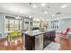 Open-concept kitchen and dining area with hardwood floors, dark cabinetry, and stainless steel appliances at 424 Hopwood Way Way, Apex, NC 27523