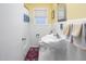 Bright bathroom featuring white tile, classic fixtures, pedestal sink, and colorful decorative rug at 4605 Erwin Rd, Durham, NC 27705