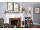 Elegant living room with a brick fireplace, hardwood floors, and decoratively adorned mantle at 4605 Erwin Rd, Durham, NC 27705