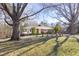 Charming one-story brick home with mature trees and manicured front lawn on a sunny day at 4605 Erwin Rd, Durham, NC 27705