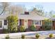 Beautiful brick home featuring manicured landscaping, a chimney, and a bright yellow front door at 4605 Erwin Rd, Durham, NC 27705