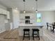 New kitchen boasts a modern island with stools, stainless appliances, and sleek white cabinetry at 472 Springtooth Dr, Zebulon, NC 27597