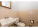 Small bathroom with a white sink and toilet, and beige-tiled walls with matching mirror at 4816 Stafford Dr, Durham, NC 27705