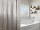 Relaxing bathroom with bathtub, decorative shelves, and window with natural light at 55 Oak Leaf Dr, Lillington, NC 27546