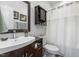 Well-lit bathroom with a modern sink, dark vanity, and shower with curtain at 55 Oak Leaf Dr, Lillington, NC 27546