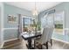 Light-filled dining room boasts modern chandelier, large windows, light-blue paint, and a dark table at 55 Oak Leaf Dr, Lillington, NC 27546