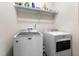 Functional laundry room with washer, dryer, and overhead storage shelf at 55 Oak Leaf Dr, Lillington, NC 27546