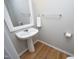 Pedestal sink in the bathroom with decorative mirror and wood flooring at 5526 Spindlewood Ct, Durham, NC 27703