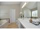 Bathroom featuring a spacious countertop, ample lighting, and a decorative mirror, offering functionality at 5526 Spindlewood Ct, Durham, NC 27703
