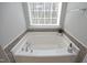 Relaxing bathtub with tiled accents, offering a cozy spot for unwinding after a long day at 5526 Spindlewood Ct, Durham, NC 27703
