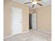 Carpeted bedroom featuring a ceiling fan and two white doors at 5636 Thom Rd, Mebane, NC 27302
