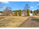 Exterior view featuring a long driveway, detached garage, and a well-maintained lawn and landscaping at 5636 Thom Rd, Mebane, NC 27302