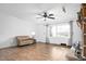 Living room featuring hardwood floors, a ceiling fan, and a cozy armchair next to a window at 5636 Thom Rd, Mebane, NC 27302
