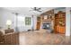 Spacious living room with hardwood floors, a stone fireplace, built-in shelves, and large windows at 5636 Thom Rd, Mebane, NC 27302