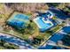 Overhead view of community amenities, featuring a pool, tennis courts, playground, and surrounding landscape at 5812 Solitude Way, Durham, NC 27713
