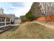 Spacious backyard featuring a wood fence, mature trees, and a cozy fire pit area for relaxing evenings at 5812 Solitude Way, Durham, NC 27713