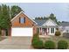 Charming brick home featuring an attached two-car garage and manicured landscaping at 5812 Solitude Way, Durham, NC 27713
