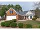 Charming brick home featuring an attached two-car garage, manicured landscaping, and a well-maintained lawn at 5812 Solitude Way, Durham, NC 27713
