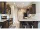 Modern kitchen features dark wood cabinets, stainless appliances, barstool seating and light wood flooring at 59 Peduncle St, Selma, NC 27576