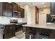 Well-lit kitchen features granite countertops, dark cabinets, stainless appliances and center island with barstool seating at 59 Peduncle St, Selma, NC 27576