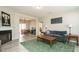 Open-concept living room with fireplace flowing into dining area and plush grey sofa atop green carpet at 59 Peduncle St, Selma, NC 27576
