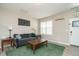 Well-lit living room with a plush grey sofa, neutral paint, laminate floors, and natural light streaming through the window at 59 Peduncle St, Selma, NC 27576