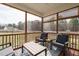 Screened porch with stylish furniture, ceiling fan, and view of the wooded backyard at 59 Peduncle St, Selma, NC 27576