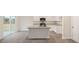 Well-lit kitchen with island, white cabinets, gray countertop, and stainless steel microwave at 6032 Sodium St, Raleigh, NC 27610