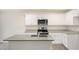 Stylish kitchen featuring an island with gray countertop, white cabinetry, and stainless steel appliances at 6032 Sodium St, Raleigh, NC 27610