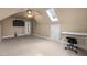 Spacious finished attic featuring neutral carpeting, a skylight, and a ceiling fan for comfortable living at 6106 Bent Oak Dr, Durham, NC 27705