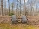 Landscaped backyard featuring chairs, a side table, and mature trees, creating a relaxing outdoor space at 6106 Bent Oak Dr, Durham, NC 27705
