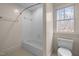 Clean white bathroom with a standard tub and shower, along with a bright window at 6106 Bent Oak Dr, Durham, NC 27705