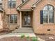 Elegant entrance with a covered porch, arched windows, and meticulous landscaping at 6106 Bent Oak Dr, Durham, NC 27705