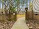Charming gated entrance leading to the property, surrounded by lush greenery and trees at 6106 Bent Oak Dr, Durham, NC 27705