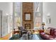 Elegant living room with stone fireplace, tall windows, hardwood floors and high ceilings at 6106 Bent Oak Dr, Durham, NC 27705