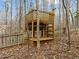Multi-level wooden treehouse nestled among mature trees, providing a fun outdoor space at 6106 Bent Oak Dr, Durham, NC 27705