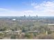 An aerial view showing the property surrounded by trees and the city skyline in the background at 6301 King Lawrence Rd, Raleigh, NC 27607