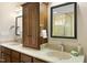 Bright bathroom with dual sinks, wood cabinets, granite counters and decorative wall mirrors, with a shower in view at 6301 King Lawrence Rd, Raleigh, NC 27607