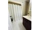 Neutral bathroom with shower featuring a white curtain, white tiled floors, and vanity with storage at 6301 King Lawrence Rd, Raleigh, NC 27607