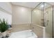 Bright bathroom featuring a large tub and glass shower with a window and decorative items in the background at 6301 King Lawrence Rd, Raleigh, NC 27607
