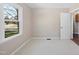 Bright bedroom with neutral walls, carpet, and a sun-filled window overlooking the side yard at 6301 King Lawrence Rd, Raleigh, NC 27607