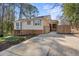 Tan home featuring a pergola, blue shutters, and a concrete driveway at 6301 King Lawrence Rd, Raleigh, NC 27607